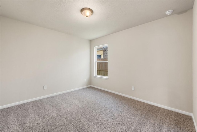 carpeted empty room featuring a textured ceiling