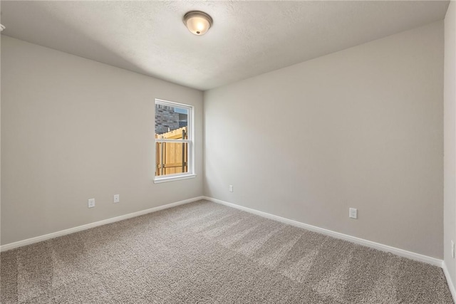 unfurnished room with carpet and a textured ceiling