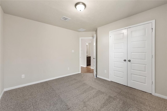 unfurnished bedroom featuring carpet flooring and a closet