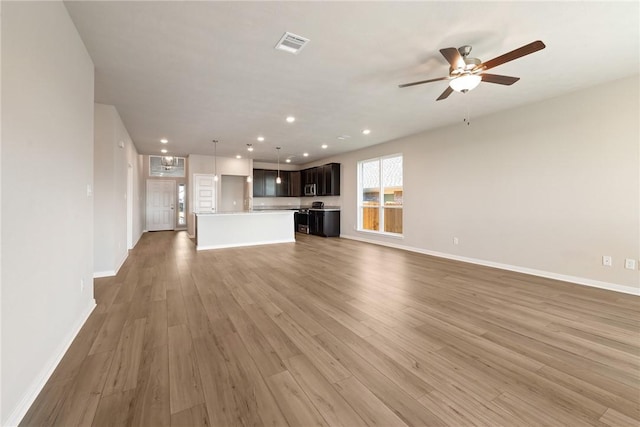 unfurnished living room featuring ceiling fan and wood-type flooring