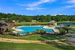 view of swimming pool featuring a lawn and a water view