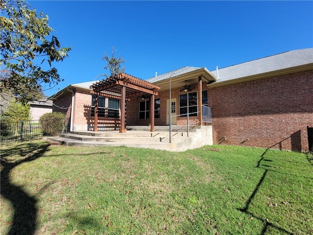 rear view of property featuring a pergola, ceiling fan, a patio area, and a lawn