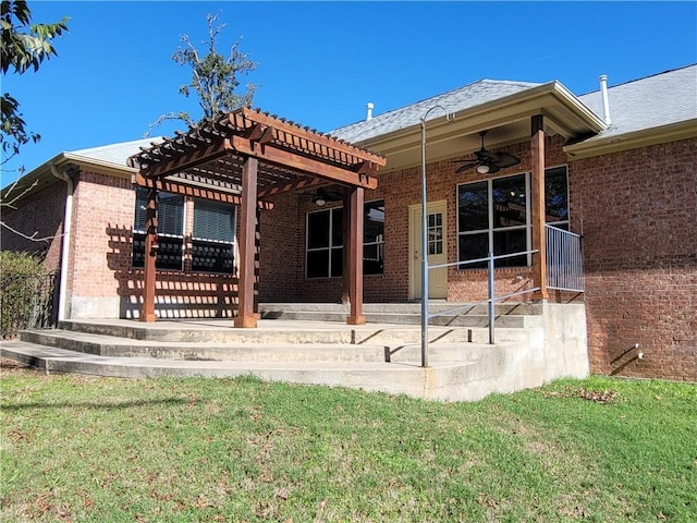 back of property with a pergola, ceiling fan, and a lawn