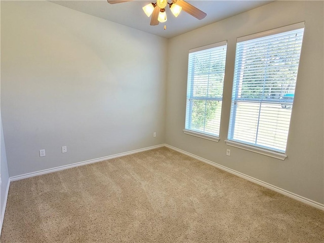 empty room featuring carpet, ceiling fan, and a healthy amount of sunlight