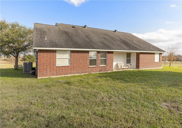 rear view of property featuring a yard and central AC unit