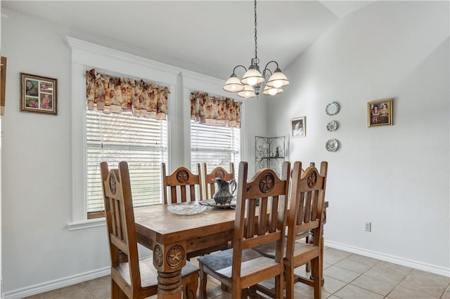 tiled dining area with a chandelier and vaulted ceiling