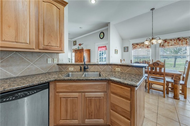 kitchen featuring kitchen peninsula, stainless steel dishwasher, sink, light tile patterned floors, and an inviting chandelier