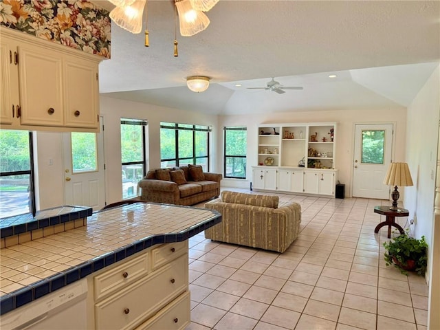 28 Sammy Snead Dr, Hilltop Lakes, TX 77871 - living room featuring a ceiling fan, vaulted ceiling, plenty of natural light, light tile patterned floors, and a textured ceiling