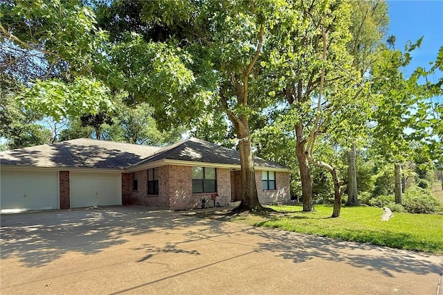 28 Sammy Snead Dr, Hilltop Lakes, TX 77871 - view of front of property with an attached garage, concrete driveway, brick siding, a front lawn, and a shingled roof