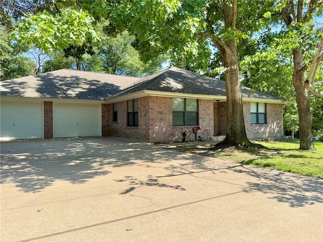 28 Sammy Snead Dr, Hilltop Lakes, TX 77871 - ranch-style home featuring a garage, driveway, brick siding, and roof with shingles