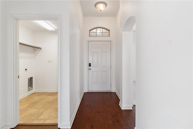 doorway featuring dark wood-style floors, baseboards, and arched walkways