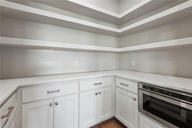 10732 Harvey Ranch Rd, College Station, TX 77845 - kitchen featuring white cabinets, open shelves, dark wood-style floors, and light stone countertops
