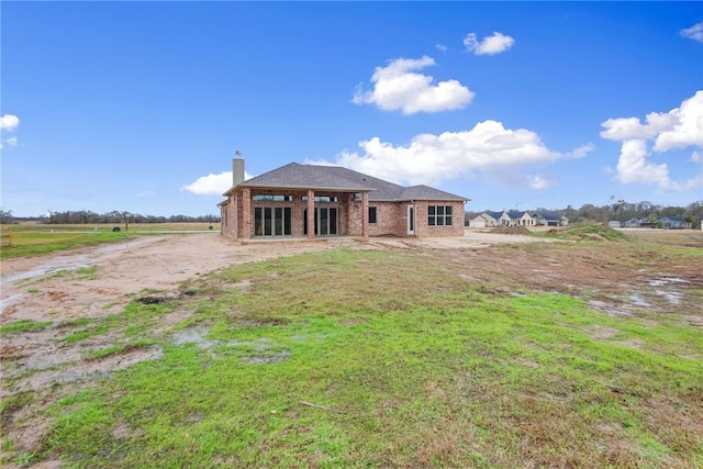 back of house with a lawn