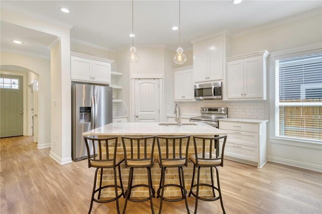 2124 Mountain Wind Loop, Bryan, TX 77807 - kitchen with stainless steel appliances, light countertops, arched walkways, white cabinetry, and decorative backsplash