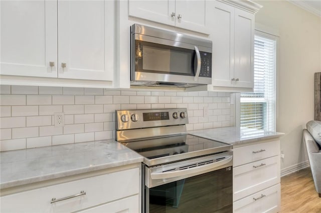 2124 Mountain Wind Loop, Bryan, TX 77807 - kitchen with stainless steel appliances, light stone countertops, backsplash, white cabinets, and light wood-style floors
