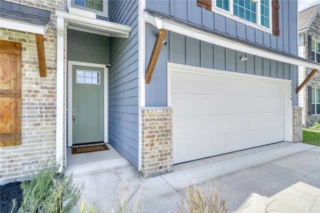 2124 Mountain Wind Loop, Bryan, TX 77807 - doorway to property with a garage, board and batten siding, brick siding, and driveway