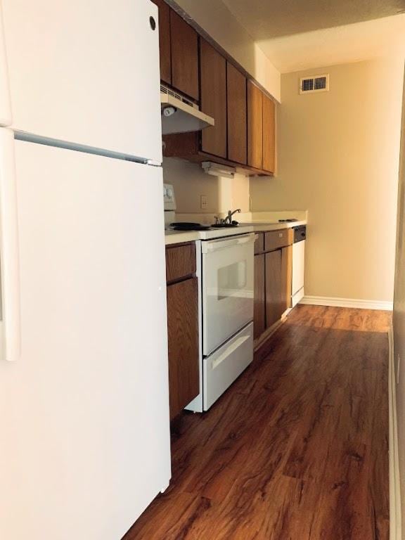 kitchen with dark wood-type flooring and white appliances