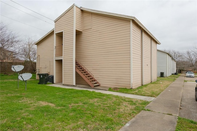 view of home's exterior with cooling unit and a yard