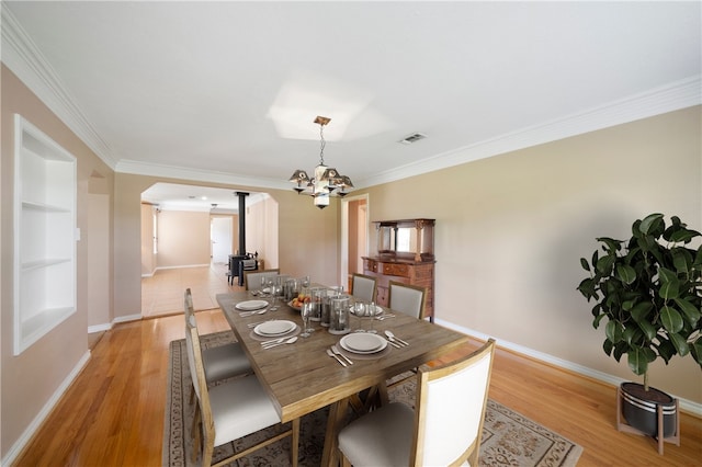 dining space featuring crown molding, light hardwood / wood-style floors, and an inviting chandelier