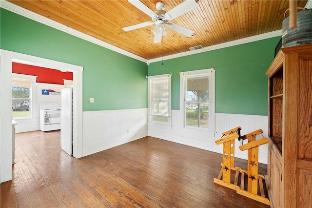 spare room featuring wood-type flooring, ceiling fan, crown molding, and wood ceiling