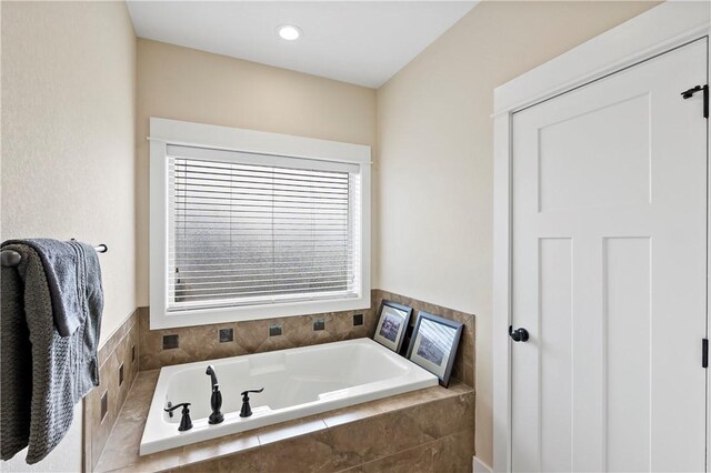 bathroom with a garden tub and recessed lighting
