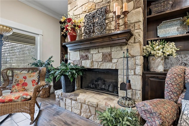 living area with crown molding, a fireplace, and wood finished floors