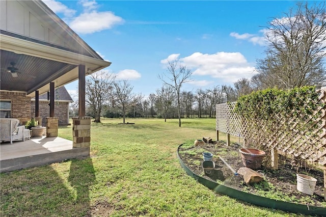 view of yard featuring a ceiling fan and a patio area