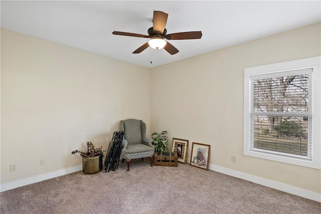 sitting room featuring baseboards, ceiling fan, and carpet flooring