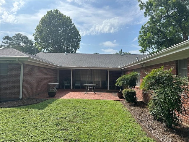 604 W Buck St, Caldwell, TX 77836 - back of property featuring a patio, brick siding, a lawn, and roof with shingles