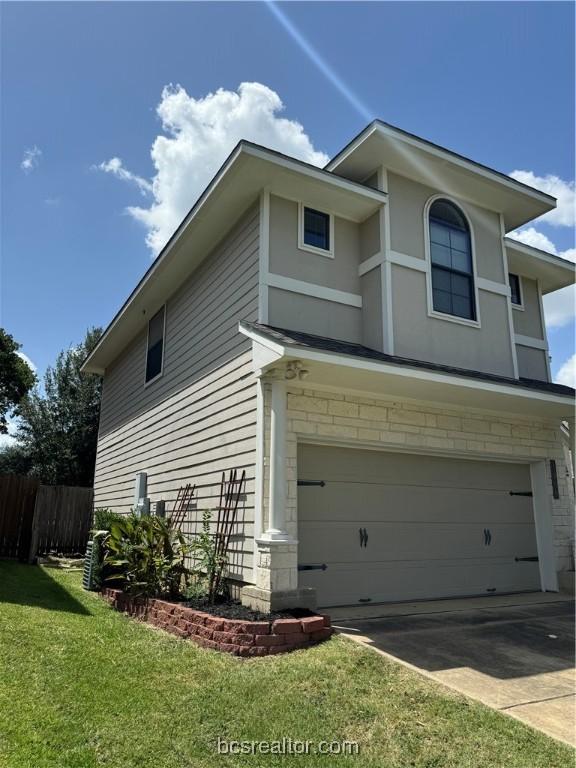 view of side of property with a yard and a garage