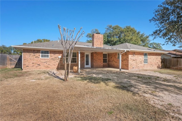 rear view of property featuring a yard and a patio