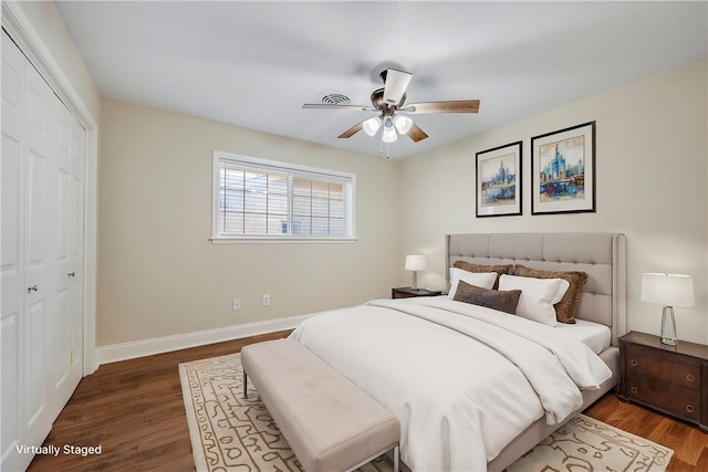 bedroom featuring ceiling fan, dark wood-type flooring, and a closet