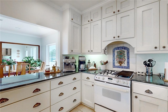 kitchen with gas range gas stove, dark stone counters, white cabinets, crown molding, and backsplash