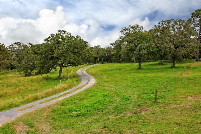 exterior space featuring a rural view and a yard