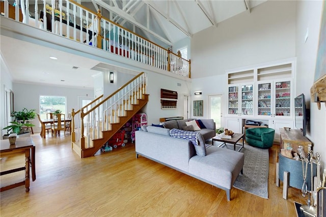 living room featuring light wood-type flooring and a high ceiling