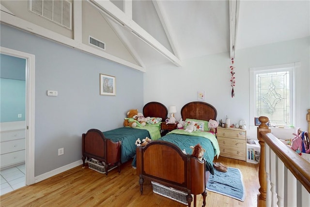 bedroom with high vaulted ceiling, light hardwood / wood-style flooring, and beam ceiling