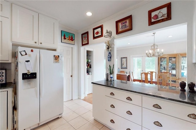 kitchen with white cabinetry, white fridge with ice dispenser, a notable chandelier, light tile patterned floors, and crown molding