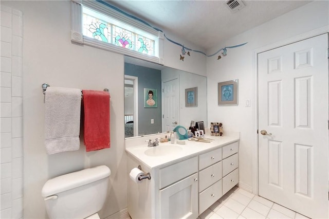 bathroom featuring toilet, tile patterned flooring, and vanity