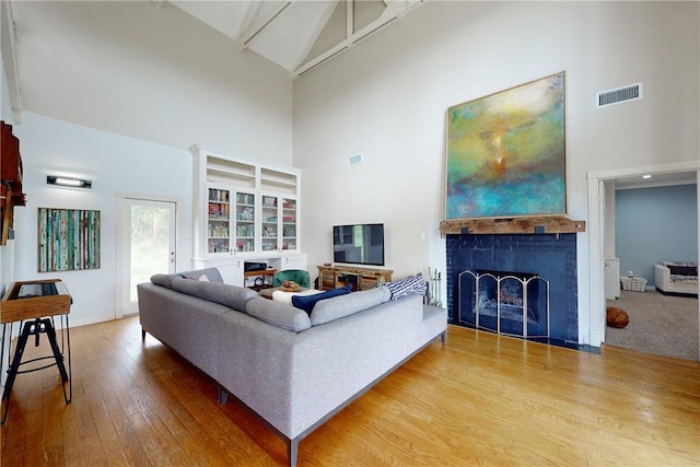 living room featuring hardwood / wood-style flooring, high vaulted ceiling, and beamed ceiling