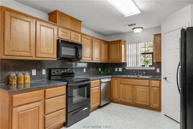 kitchen with black appliances, sink, dark stone counters, and tasteful backsplash