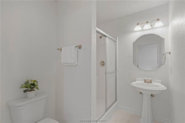 bathroom with tile patterned floors, toilet, and walk in shower