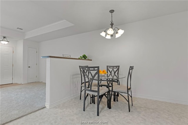 carpeted dining area featuring a chandelier