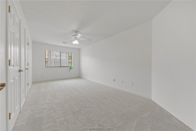 carpeted spare room featuring ceiling fan