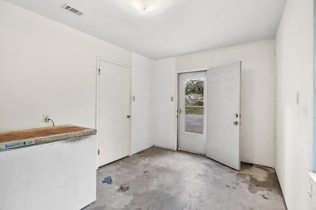 foyer entrance featuring unfinished concrete floors and visible vents
