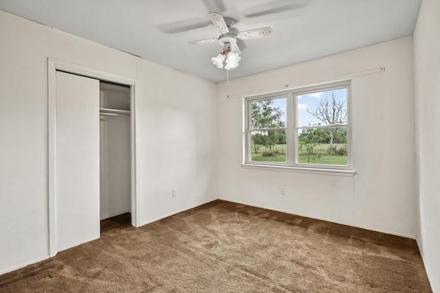 unfurnished bedroom with carpet, a closet, and a ceiling fan