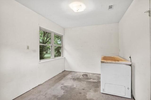 unfurnished room with visible vents and unfinished concrete flooring