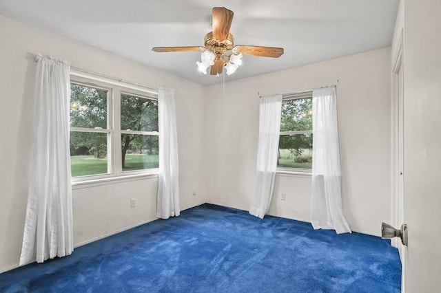 empty room with ceiling fan, a wealth of natural light, and carpet floors
