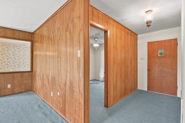 interior space featuring carpet flooring and wooden walls
