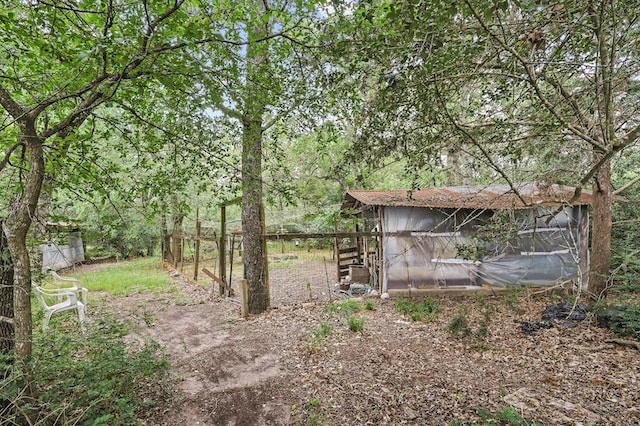 view of outbuilding with a wooded view and an outdoor structure