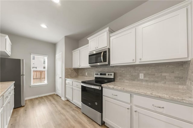 515 Hayes Ln, College Station, TX 77845 - kitchen featuring stainless steel appliances, white cabinets, tasteful backsplash, light wood finished floors, and recessed lighting